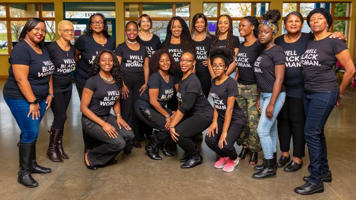 Group of Black women posing while wearing Well Black Woman t-shirts